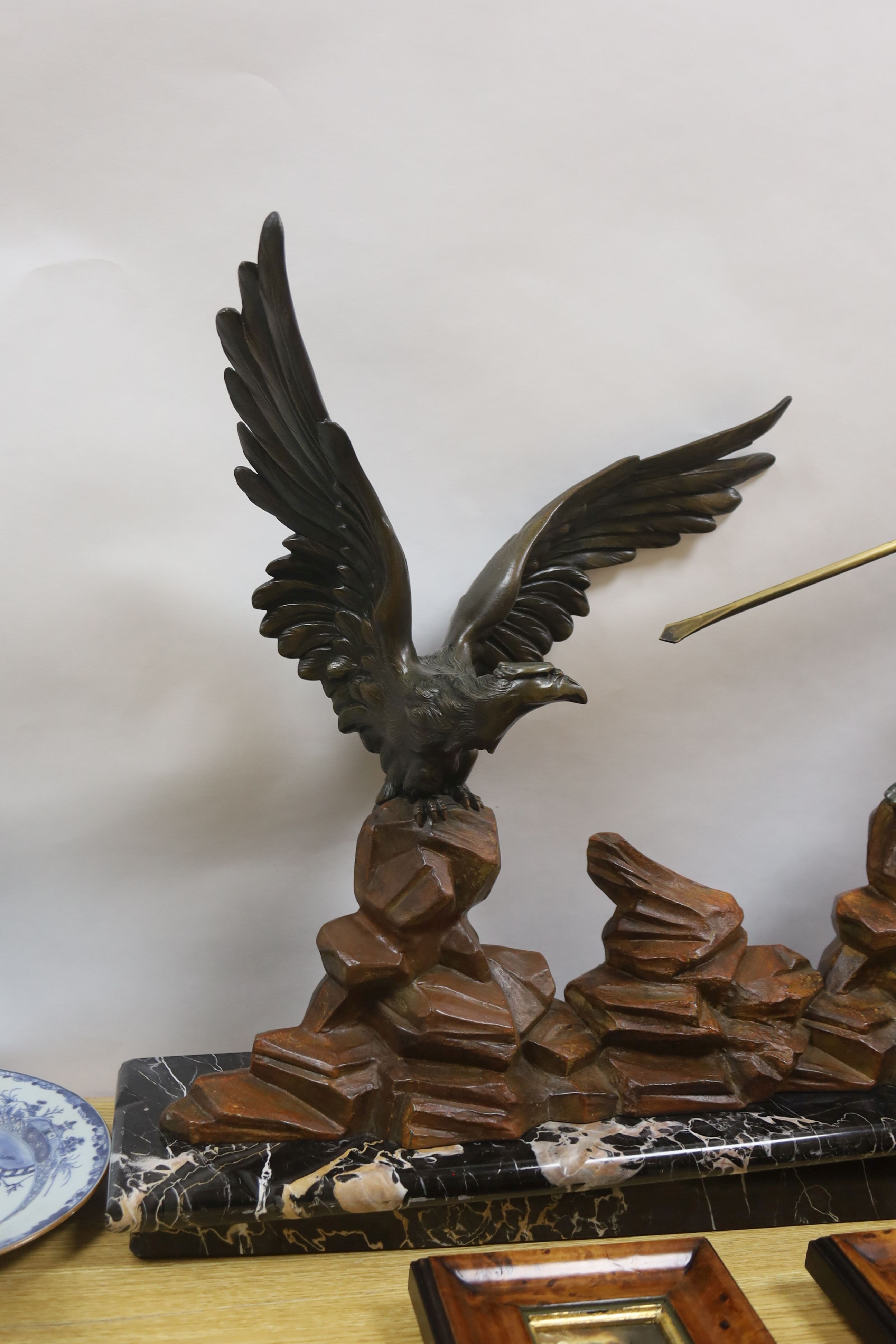 An Art Deco patinated spelter model of a hunter and eagle on a marble base - 77cm
